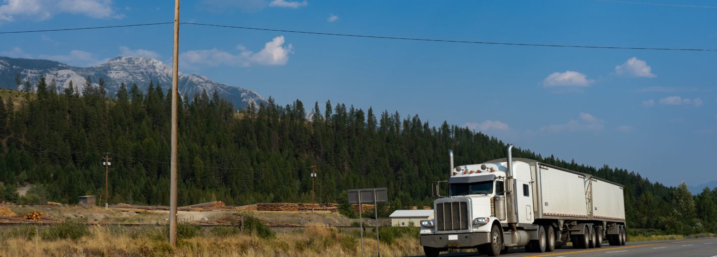 Semi-trailer truck drives along rural road